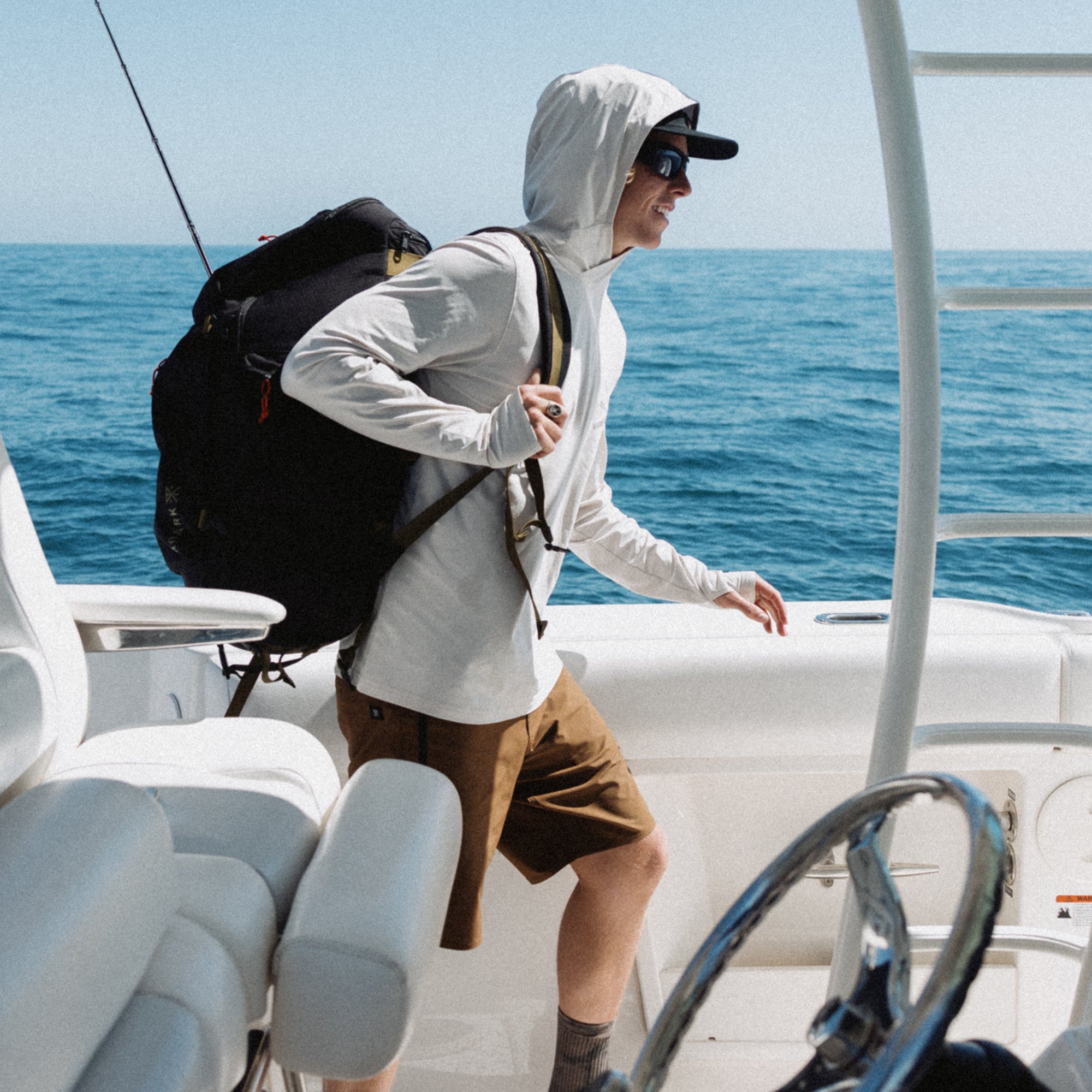 Adventure-ready setup with a stylish hat, durable travel bag, and recreational gear by the sea, perfect for exploration and leisure.
