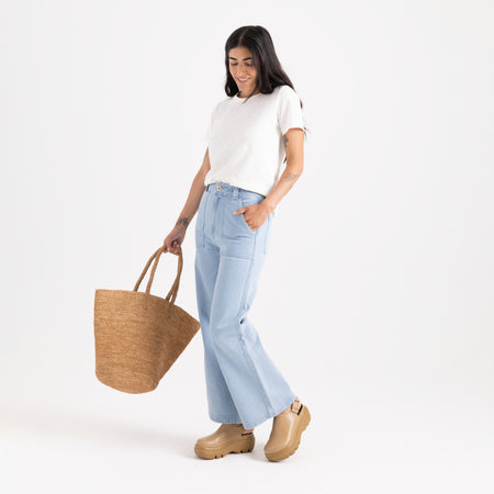 Close-up of rugged denim jeans featuring detailed stitching on pockets and durable buttons, designed for adventure and travel by Roark.