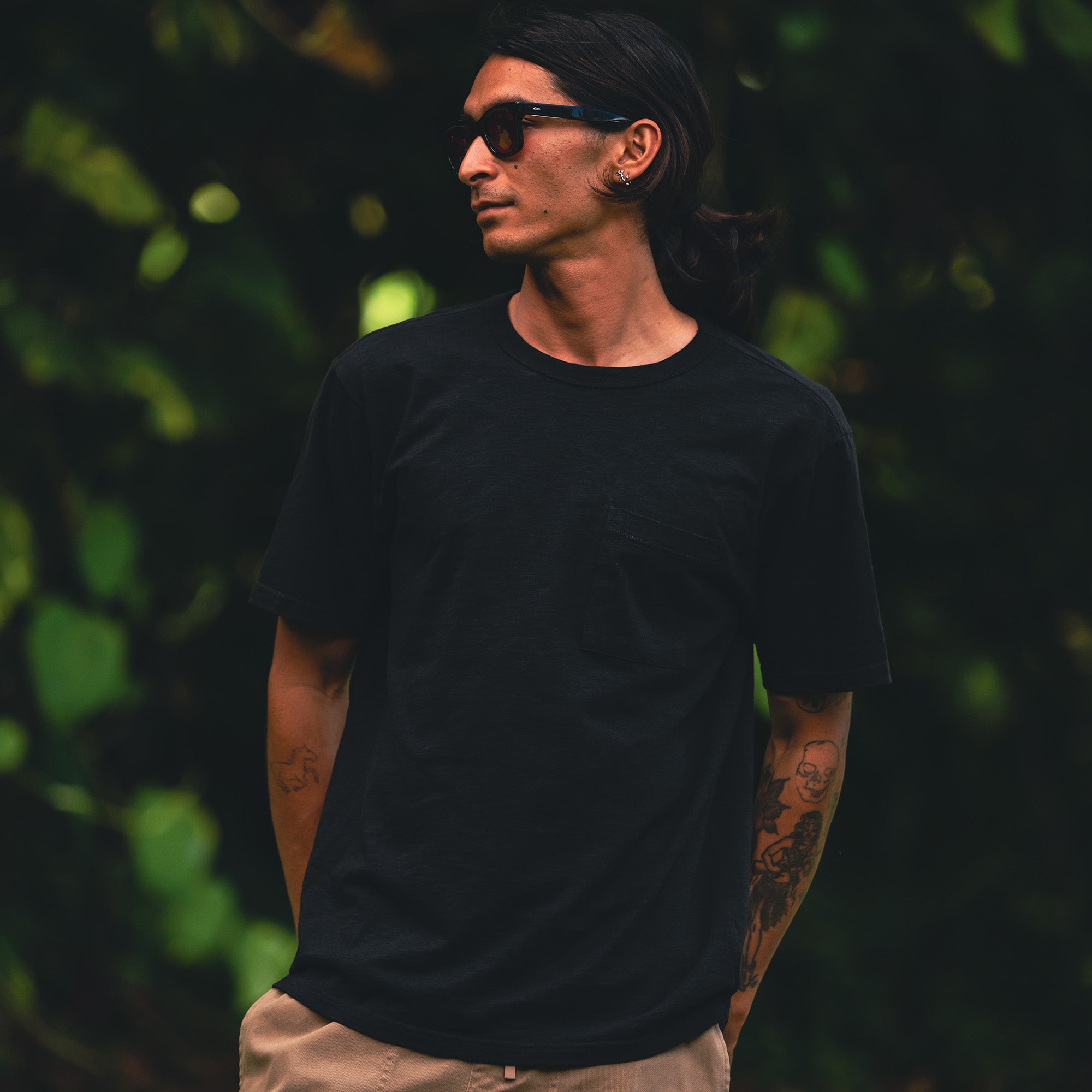 Model standing in a worn-in Roark organic short sleeve tee, showcasing the relaxed fit and natural style ideal for adventure and travel.