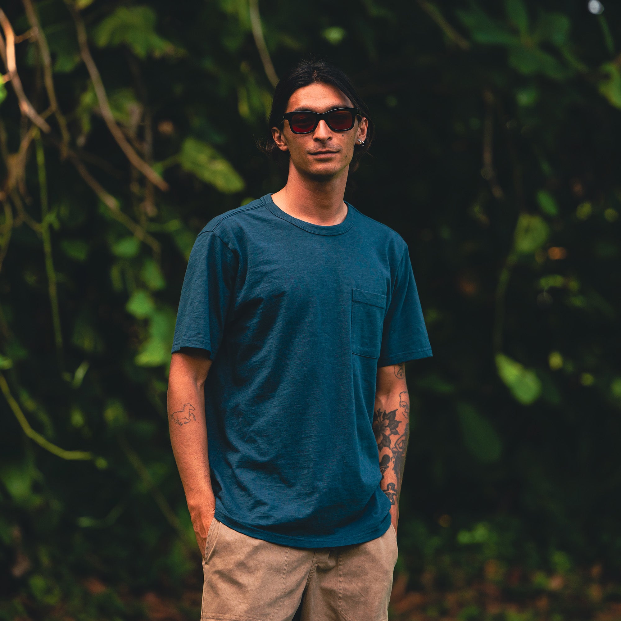 Man in a well-worn organic short sleeve tee embracing summer adventures in the outdoors, perfectly blending casual style with active functionality.